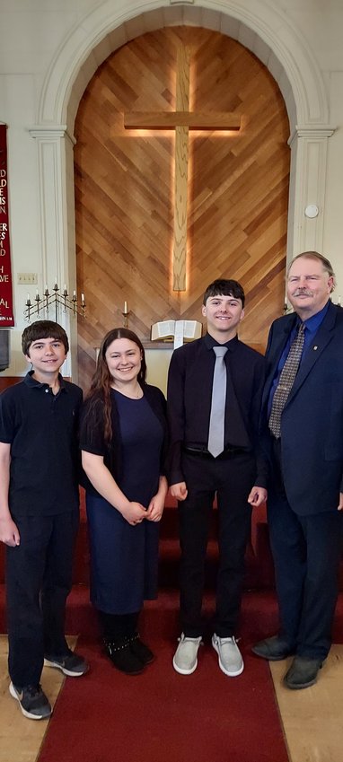 Pictured left to right: Easton Hoefs, Miley Durow, Owen Hoefs, Pastor David Neil.  Owen and Easton are sons of Beth and Steve Hoefs. Miley is the daughter of Kelsey Durow.