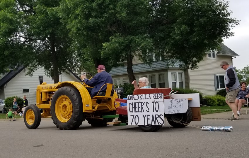 95 year-old Donald Reese drives his John Deere tractor towing a cart carrying his wife, Lila.&nbsp; The Volksfest parade entry was in honor of their 70th wedding anniversary and the sign on the back said, &quot;70 Years and she's still chasing me&quot;.&nbsp;