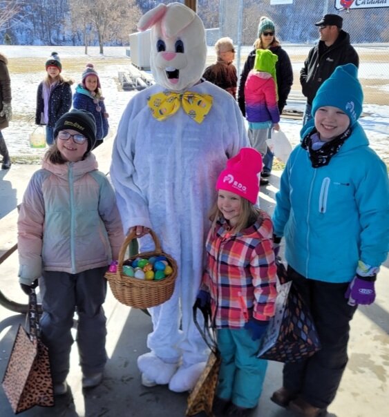 The Easter bunny sharing a photo op and Easter eggs with the kids.