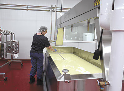 Deeann Lufkin stirs a vat of cheese on May 17 at CannonBelles cheese plan near Cannon Falls, Minnesota. The new plant is 5,800 square feet and features one 5,000 and one 1,000 pound vat.