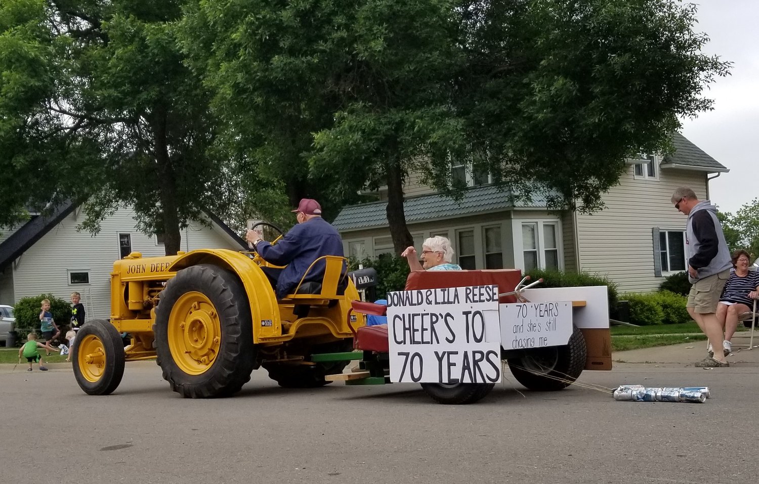 95 year-old Donald Reese drives his John Deere tractor towing a cart carrying his wife, Lila.  The Volksfest parade entry was in honor of their 70th wedding anniversary and the sign on the back said, "70 Years and she's still chasing me". 