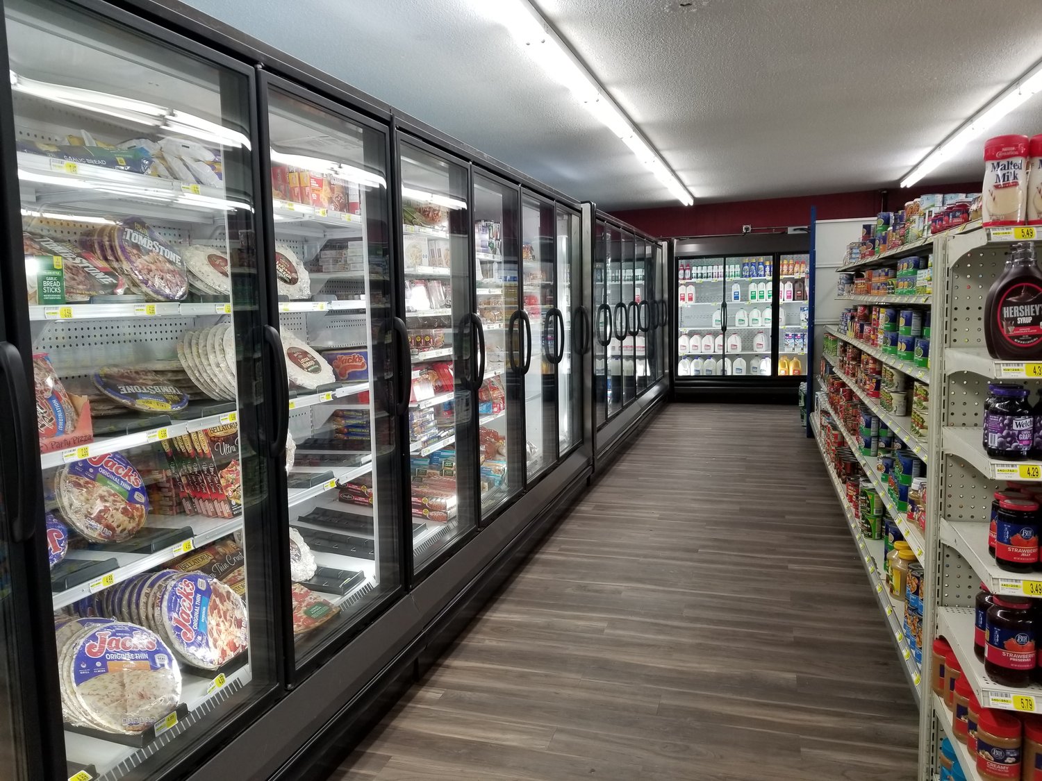 Large new coolers sit atop smooth, wood-look flooring inside the Goodhue Market grocery store.  Shelves of food and household necessities now run North and South creating a bit more room and an easy flow to shopping.