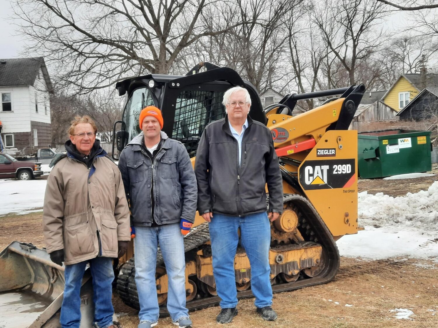Larry Lee, Wade Murray, and Will Grovender in front of the Otte Excavating skid loader to start the dirt work.
