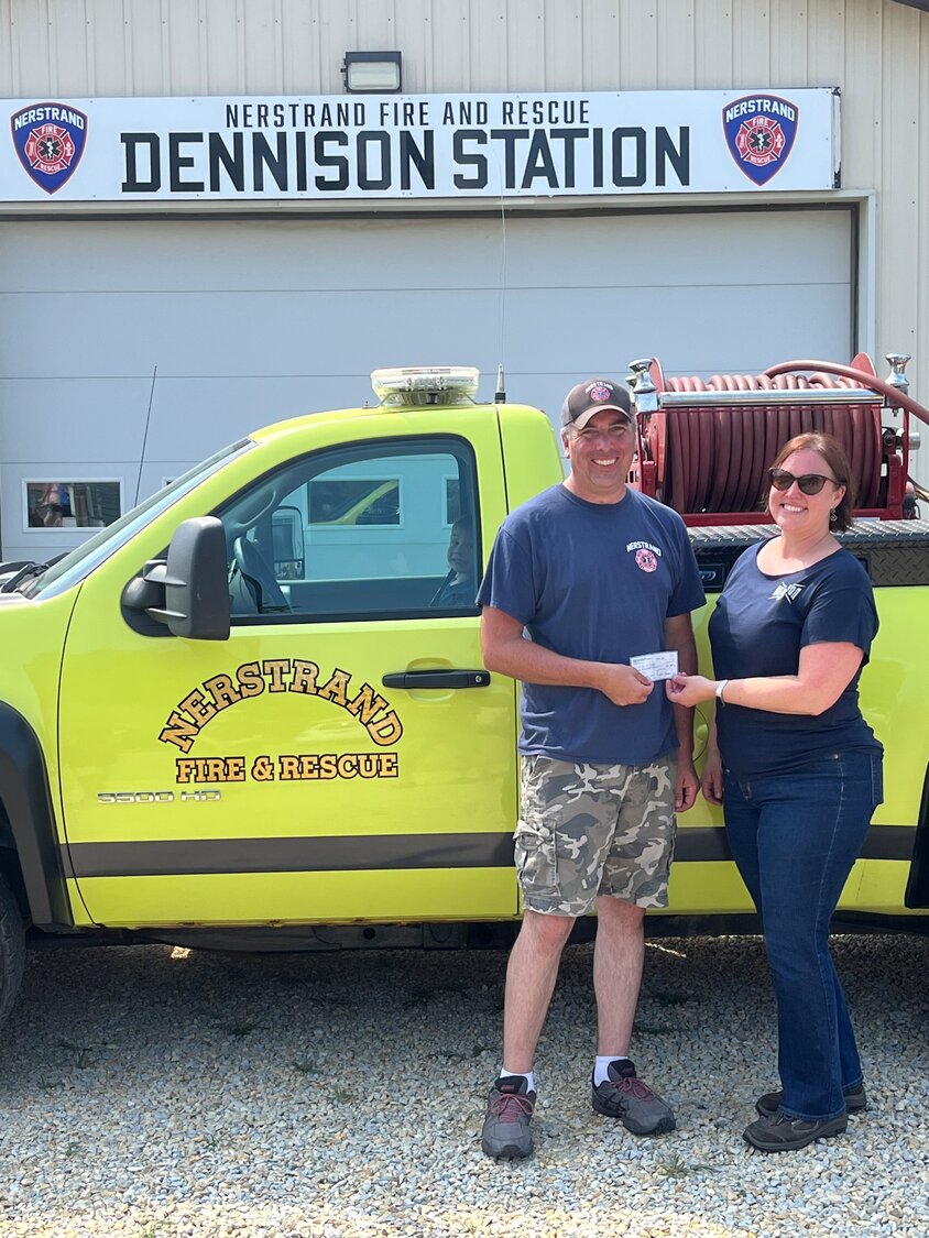 Fire Chief Joe Johnson accepts a donation from Dennison Lions Club President Diane Ruddle