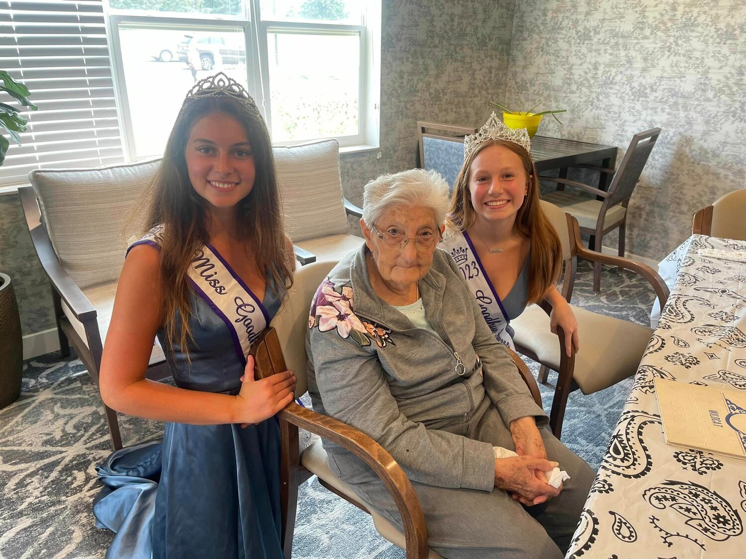Miss Goodhue, Ellie Peterson and attendant, Jordyn Lantis visit with Nita Gadient at Goodhue Living on National Senior Citizens Day.