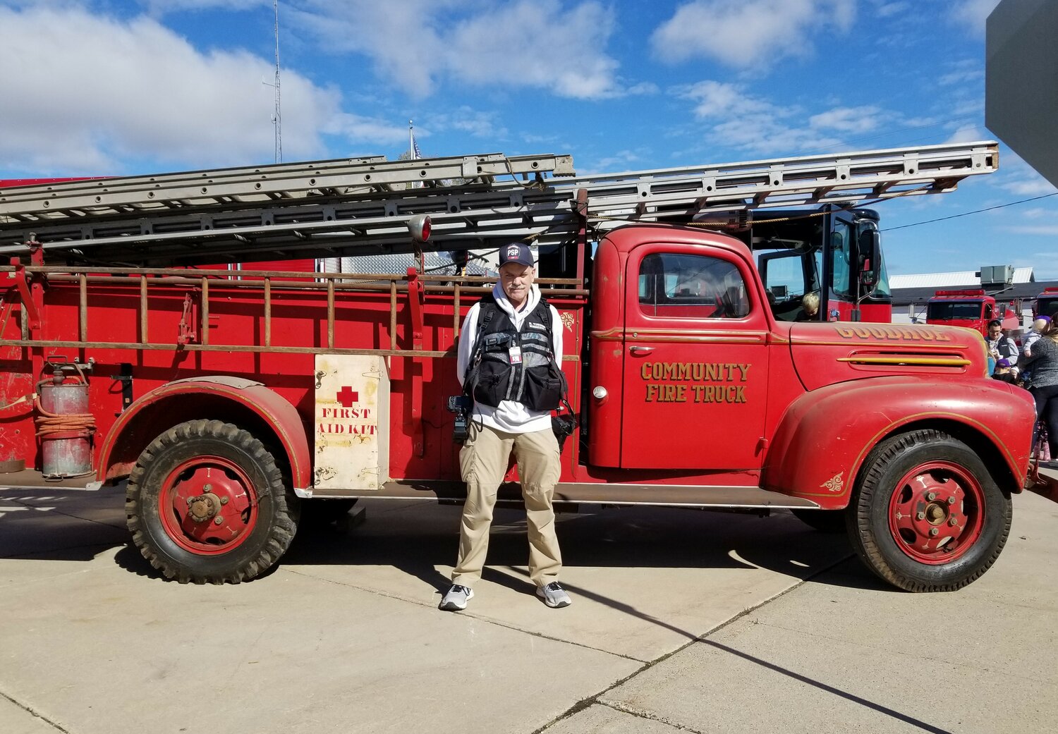 Mike Yungers, grandson of John Yungers who served on the Goodhue Fire Department in the 1930's, poses with the original 1941 fire engine that was on display next to the brand new pumper truck recently acquired by the GFD.  Yungers is a public safety photographer who has previously worked with the department and was in town for the annual open house and fundraiser on October 15th.