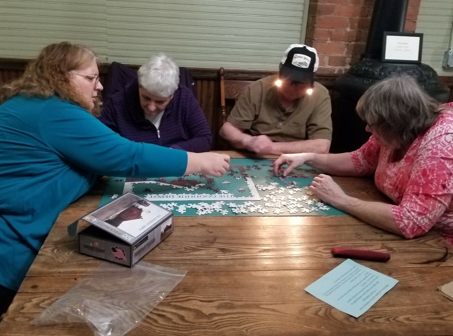 Julie Thermos, Carol Voth, Norrie Voth, and Sally Hadler work as a team to complete their puzzle during competition at The Depot.