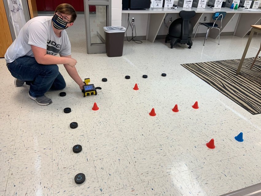 Tanner Plemmons prepares a test run on the obstacle course with one of the robot cars during the Marshfield High School Project Lead the Way Computer Science course on Thursday.
