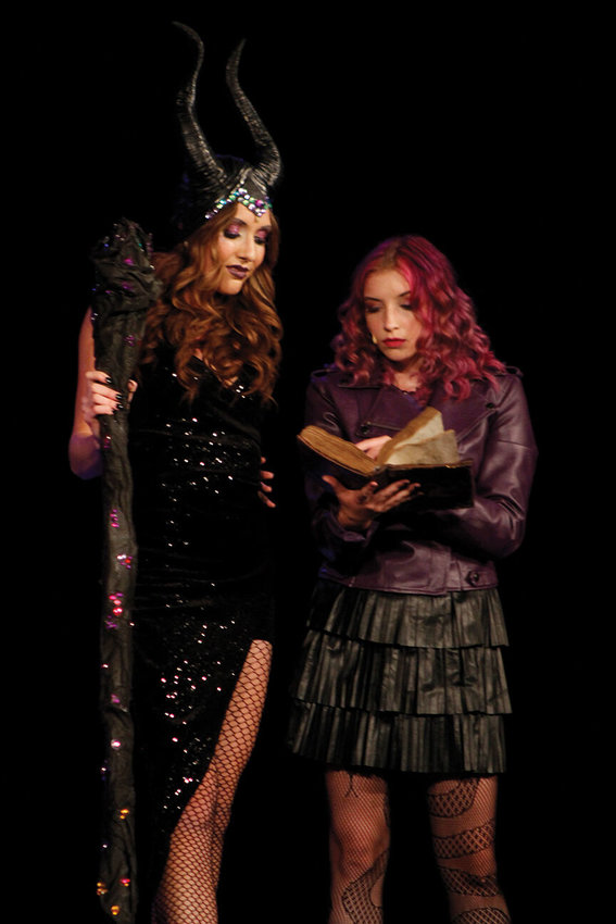 Maleficent (Kayla Buecker) lending her book of spells to her daughter Mal (Lenzie Goodman) before she leaves to Auradon.
