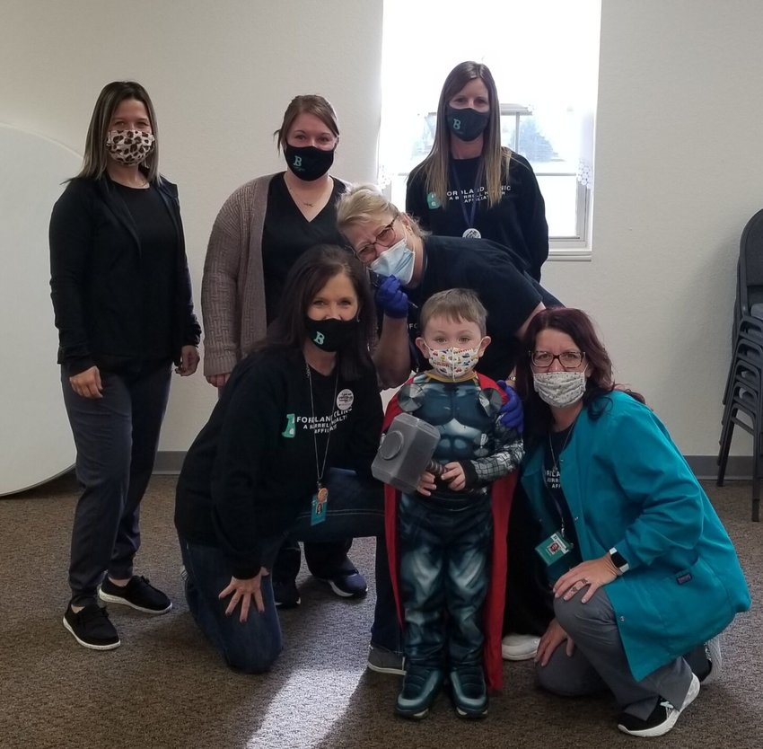 Pictured standing left to right: Jessica Cunningham, Jamie Holden and Teri Hennigh. Bottom row left to right: Jennifer Piland, Sonya Cass, Thor (Mike Farr) and Amanda Medlock pose for a photo at the clinic&rsquo;s March 30 vaccination event.