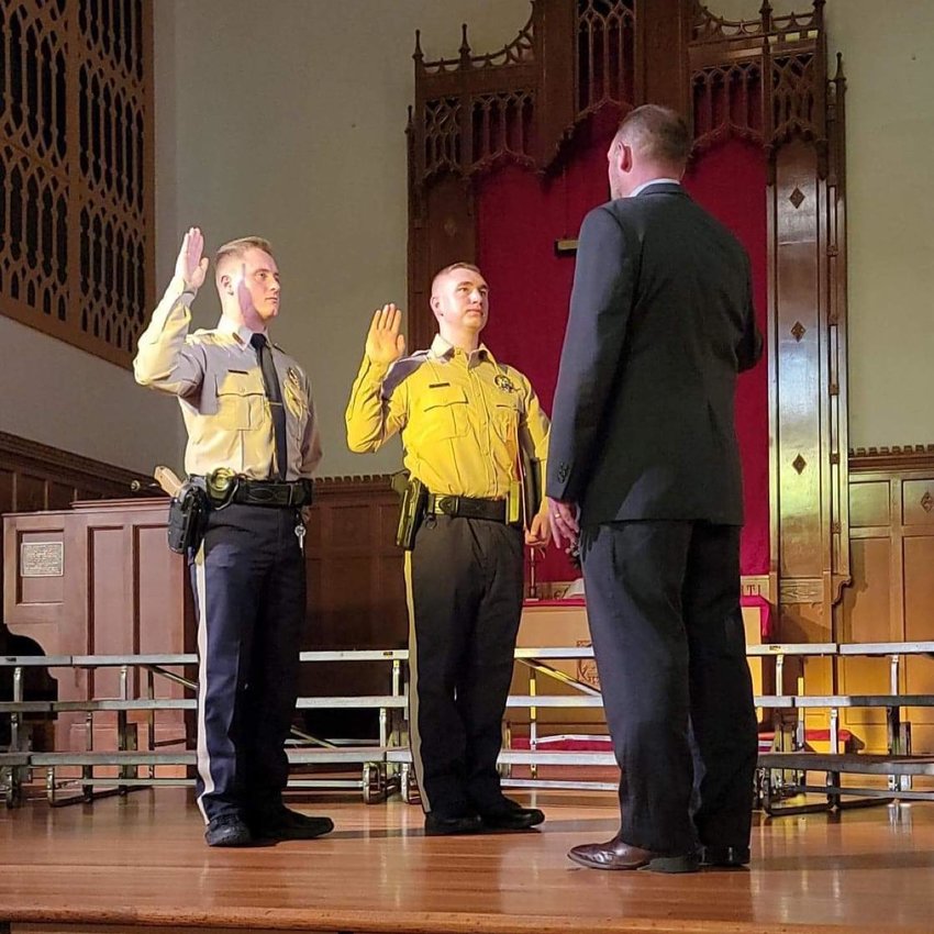 Officer Trent Genetti and Officer Blaise Dudding swear in with Webster County Sheriff Roye Cole on May 12 at Drury&rsquo;s Law Enforcement Academy.
