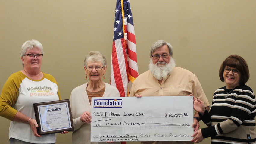 Elkland Lions Club members accept a $10,000 grant for upgrades to their building, including chairs and floor leveling.