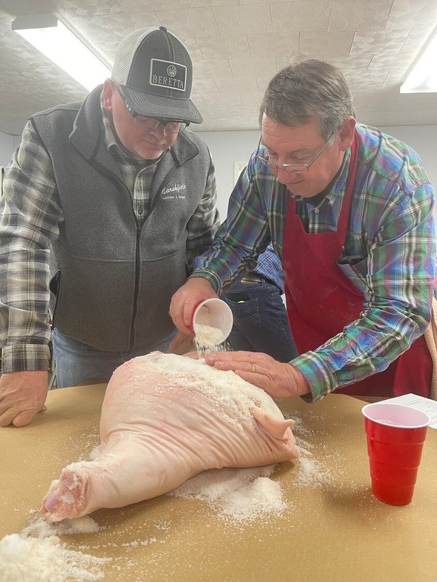 Kyle Whittaker (right) assists Webster County resident Kevin Cantrell with the curing process.&nbsp;   Mail File Photo&nbsp;