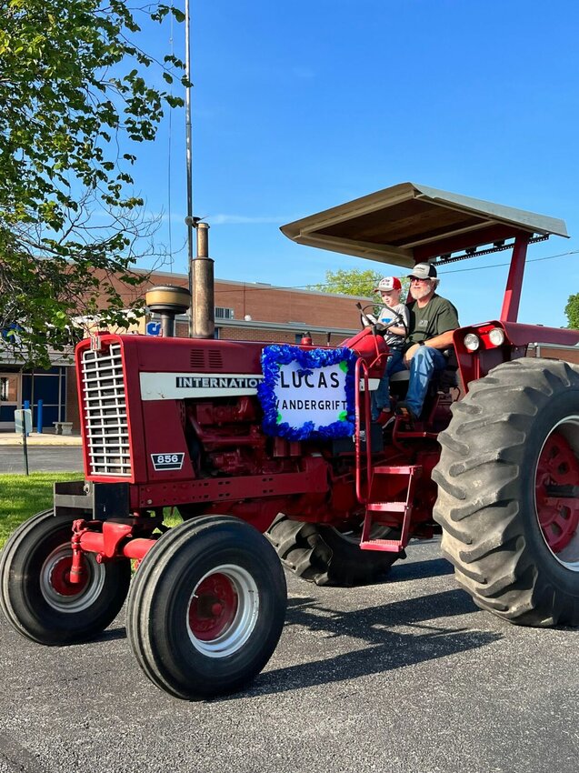 Lucas Vandergrift rides through the kindergarten graduation parade in a big red International Harvester.   Contributed photos