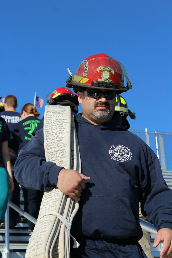 Captain Travis Cramer of the Marshfield Fire Protection District carries a memorial hose during Monday's stair climb. Written on the hose are the names of each of the 343 firefighters who passed on 9/11 as well as local service men who have been lost, including Webster County Sheriff's Office Sgt. Justin Burney, MFPD Deputy Chief Ed Noland and MFPD Lt. Matt Blankenship.&nbsp;   Photos by August Thoms