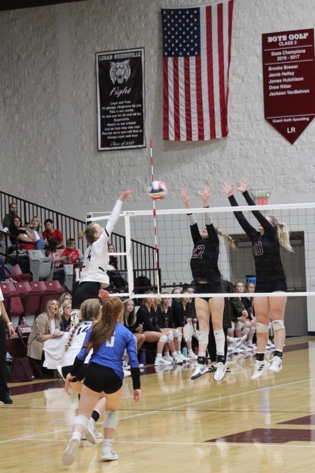 Blue Jay Abby McBride, goes up for a hit while Logan-Rogersville. (Pictured left to right) Junior Lauren Tyler and Senior Katelyn Crossland execute a block.
