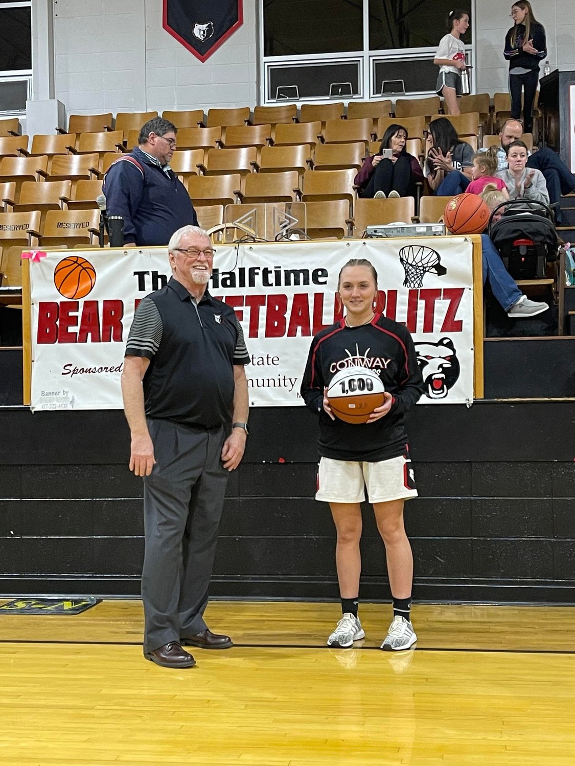 Head Coach Lynn Long presents Senior Graceson Cromer with a game ball to commemorate reaching 1,000 career points.