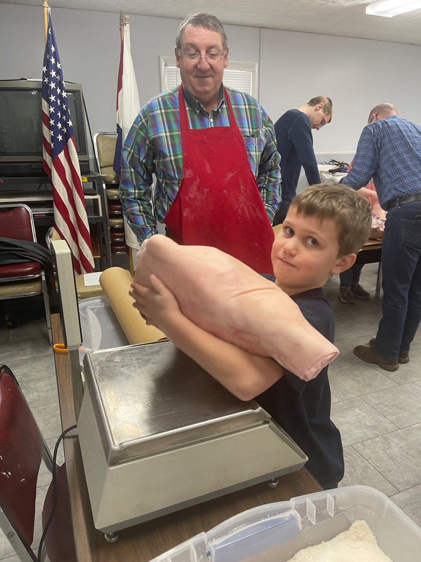 Maverick Crawford, age 8, of Marshfield prepares to cure his ham by first checking it’s weight under the watch of instructor Kyle Whittaker.