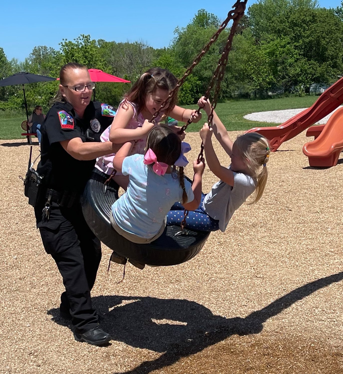 Bouncing from one swing to the next Officer Deckard took time to push the kiddos on the tire swing.
