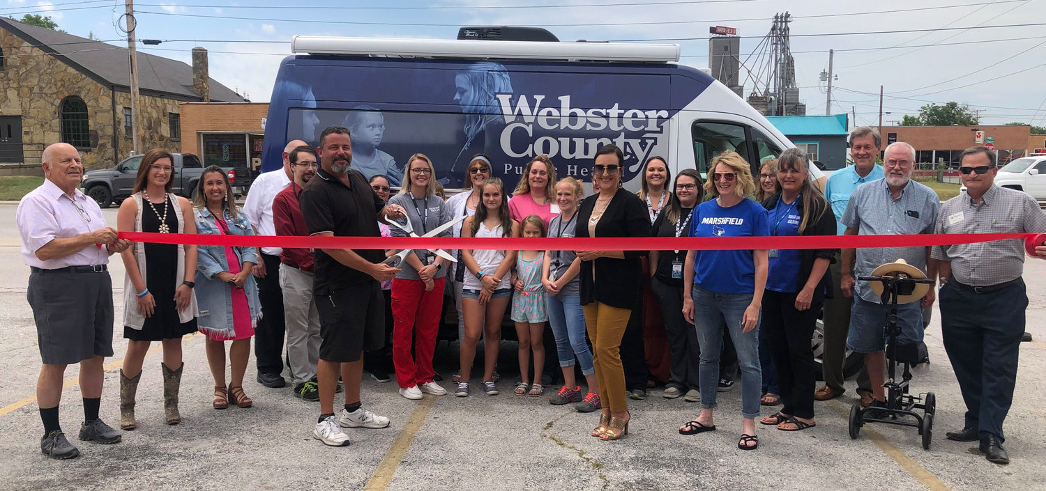 Staff from the Webster County Health Unit along with Marshfield Area Chamber of Commerce Board members and others from the community gathered around to perform the “ribbon cutting” ceremony for the Webster County Health Unit’s new mobile unit on Thursday, July 7. 