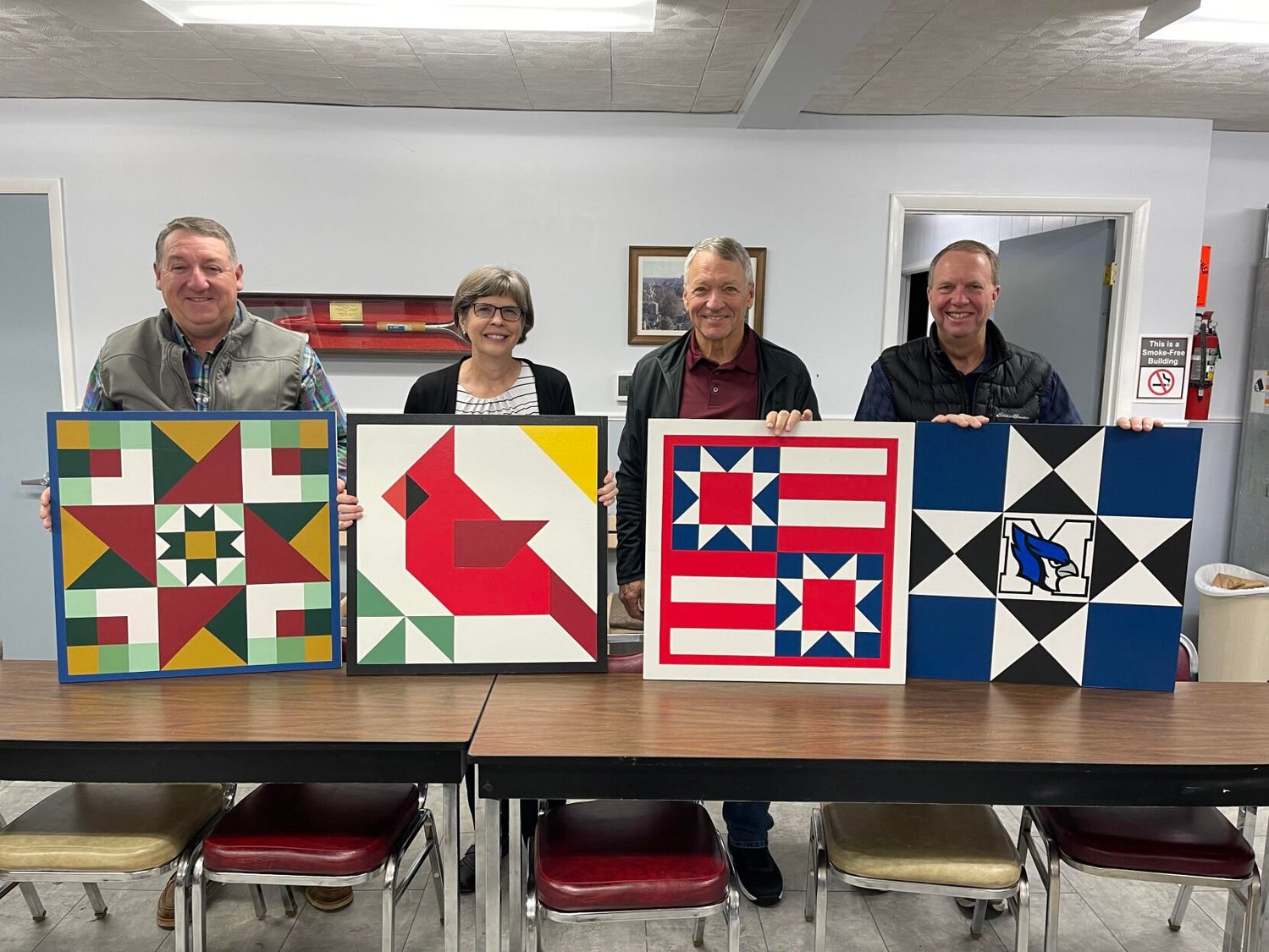 (Left to right) Kyle Whittaker, Janet Wutke, Mike Wutke and Alan Thomas show off their barn quilts. Janet, who started making barn quilts for her church, decided that she wanted to donate them to the Grow Education Marshfield fundraising efforts. The first 50 people who donate $200 to the fund will receive a barn quilt as a thank you gift. “I started teaching the barn quilt classes because there were some ladies that said ‘I wanna do this’,” laughed Whittaker. “…we want to engage people in what we do here…ultimately that’s what we are about here-to improve the lives of people that live in this county.”