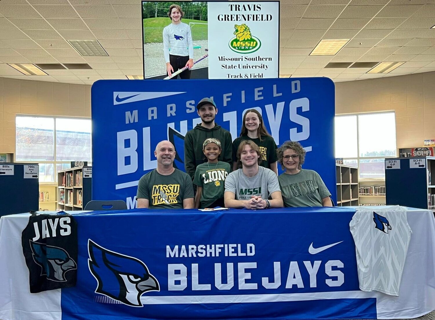 Smiling with his family is Travis Greenfield after signing his letter of intent to play track and field at Missouri Southern State University.