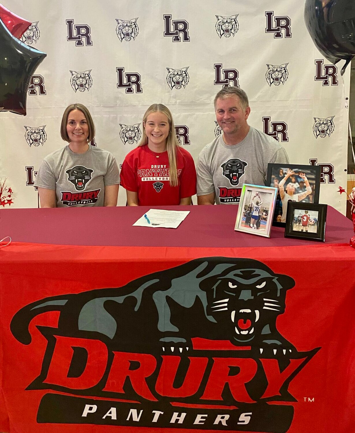 After signing her letter to play volleyball at Drury, Lauren Tyler is smiling with pride alongside her family.