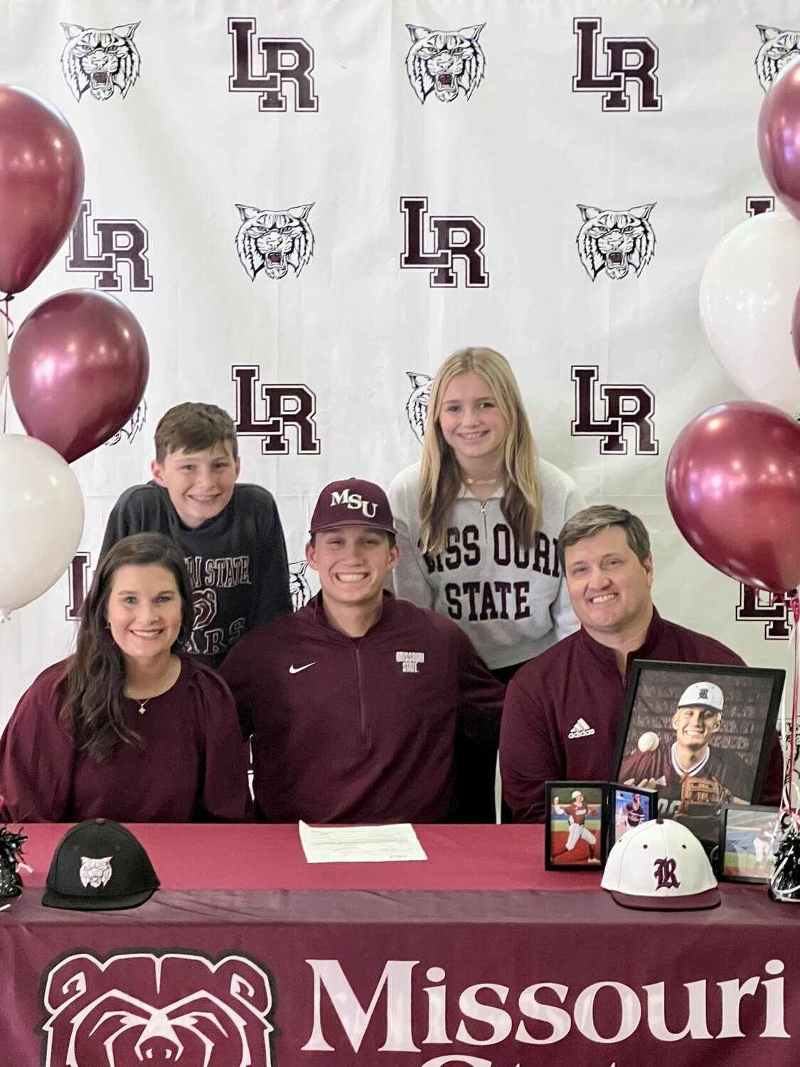 Curry Sutherland is surrounded by his family and beaming with excitement after signing his letter to play baseball at Missouri State University.