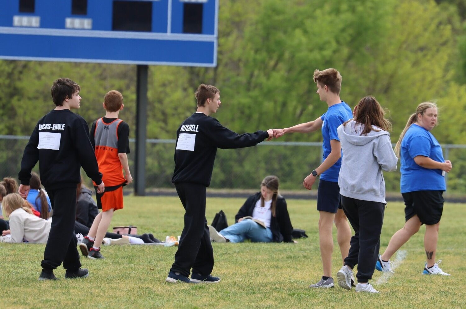 A celebratory fist bump is shared between an MHS athlete and buddy pair at the Special Olympics track meet.