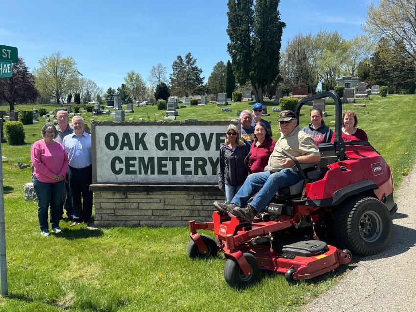 The Oak Grove Cemetery Association Trustees along with the head groundskeeper show off the new Toro riding mower. From left to right: Dawn Spence, Howard Hanson, Jeff Holthaus, Denise Baumgarten, Gene Baumgarten, Chris Anderson, Lori Roush, Reid Zohfeld (head groundskeeper), Breanne Zaremba, Debbie Hancock.