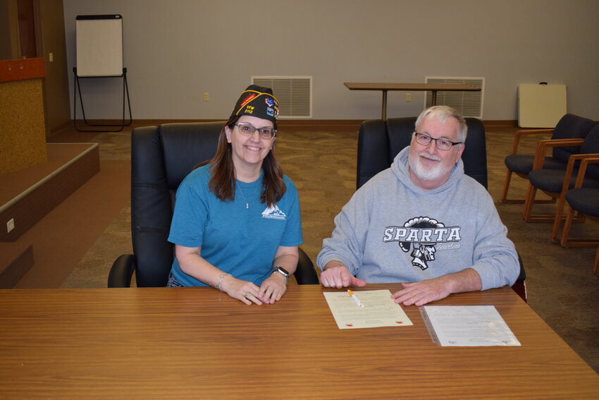 Mayor Kevin Riley signs the proclamation recognizing May as Poppy Month in the City of Sparta. Accompanying him is VFW Post 2112 Junior Voce Commander Sara Fischer.