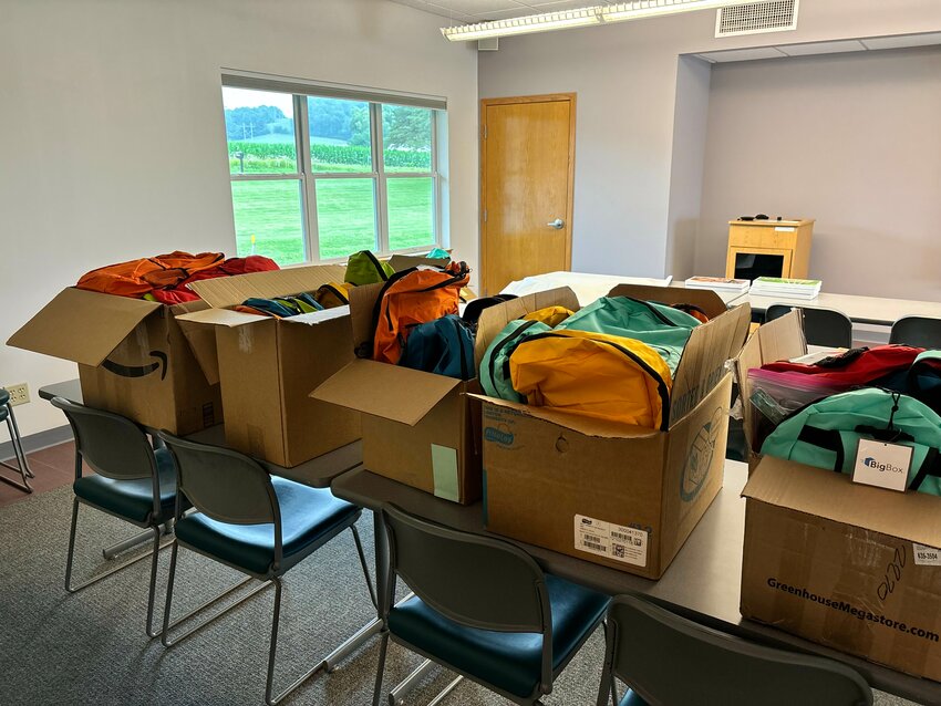 70 backpacks filled with school supplies, donated by an anonymous local business, for local elementary school students in need, await their August 1st distribution at Evans Bosshard Park in Sparta, starting at 11:15am.