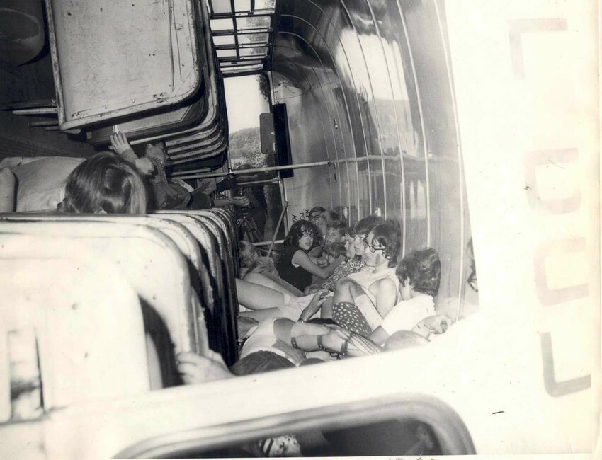 John Voss, Civil Defense employee (left) and Paul Wolf, Tomah High School Ag Teacher and FFA Advisor (right) with boxes of outdated shelter food stacked for distribution at Tomah Senior High School, Spring 1977.  FFA students assisted with distributing the supplies to area farmers.