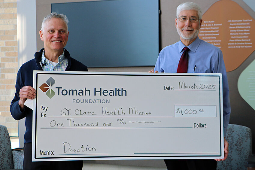 Tomah Health Community Foundation President, Brian Eirschele, left, presented a $1,000 ceremonial check to St. Clare Health Mission of Monroe County medical director, Michael Saunders, M.D.  on March 18th.