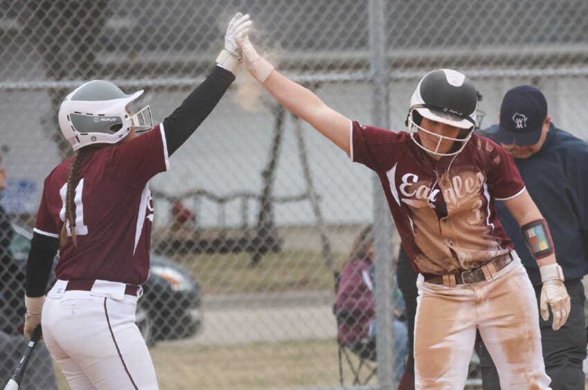 Cashton’s Marlee Schroeder (right) is met by Katie Leis (left) after diving across home plate for a score in Thursday’s game at Riverdale.