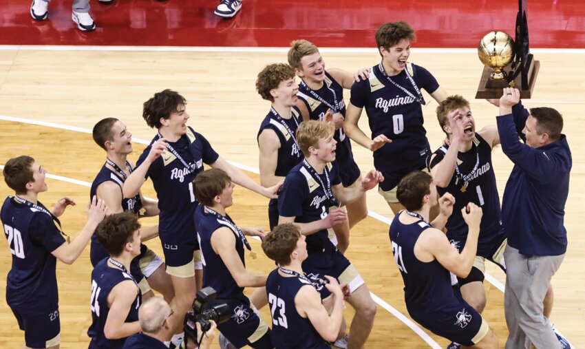 Aquinas head coach Brad Reinhart is swarmed by the Blugolds after winning the Division 4 state championship on March 22. Aquians defeated Bonduel 74-45 for the program’s fifth state tile.