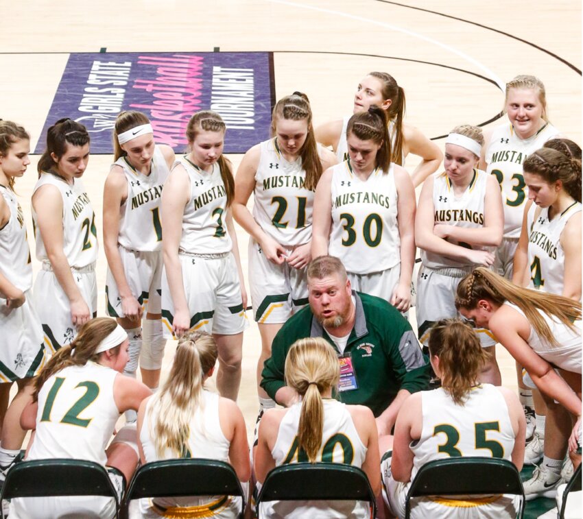 Melrose-Mindoro head coach Joey Arneson talks to his team during a timeout in the 2020 Division 4 state semifinals. Opposite the team bench is a nearly vacant arena as attendance was limited due to the onset of the COVID-19 pandemic.