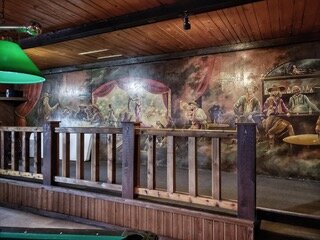 The mural at the Roadhouse Saloon depicting previous visitors to the bar.
