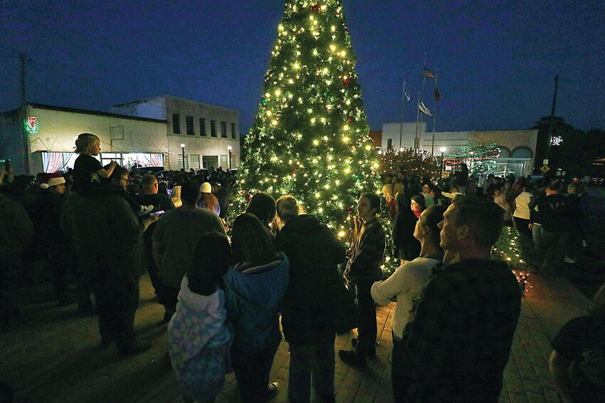 Visitors take photos as Polk Square is illuminated.