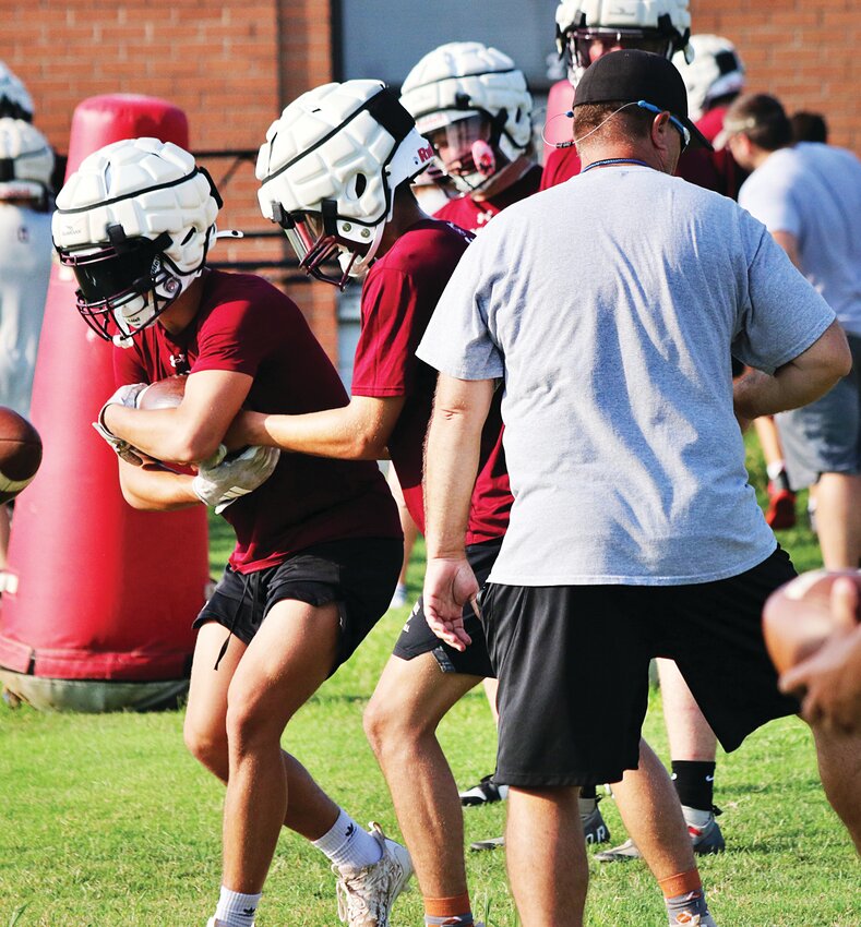 Head football coach Eric Henderson puts the Eagles through their paces in practice on July 15.