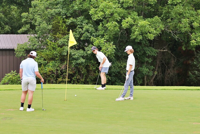 Peyden Thomas, Jackson Hudgins and Jaxon Ferguson practice at Oakridge Country Club Monday afternoon. They are members of the Huntsville High School golf team, which this year has Brian Garrett as the head coach.