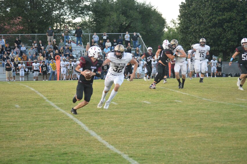 Huntsville quarterback Brett Henderson tries to outrun a Clinton defender during the Eagles’ 42-8 loss in the home-opener at Eagle Stadium on Friday.