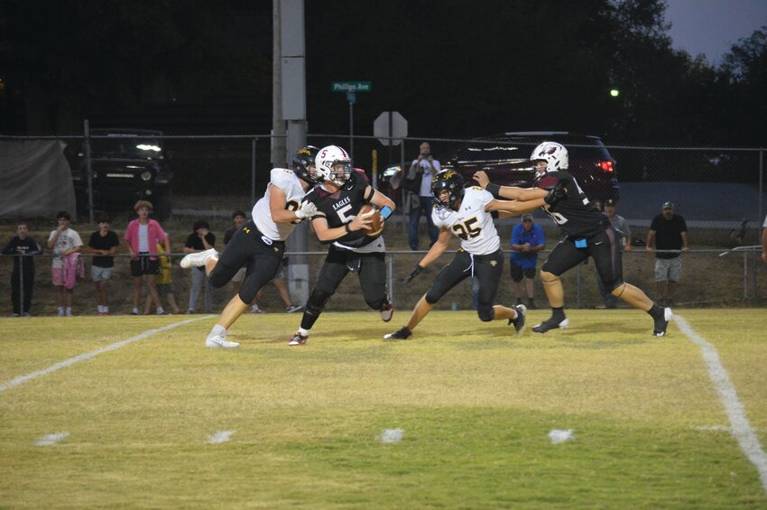 Huntsville quarterback Marcus Shepherd tries to elude the Prairie Grove rush.