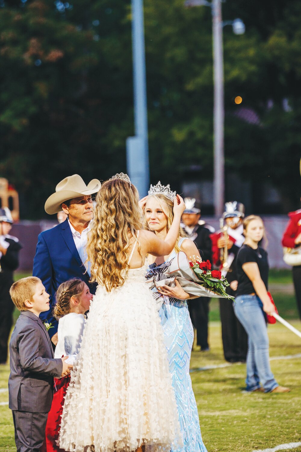 Returning 2022 Homecoming Queen, Savannah Villines, crowned Faith, with junior escorts Clayton Comer and Mallorie Thomas looking on.