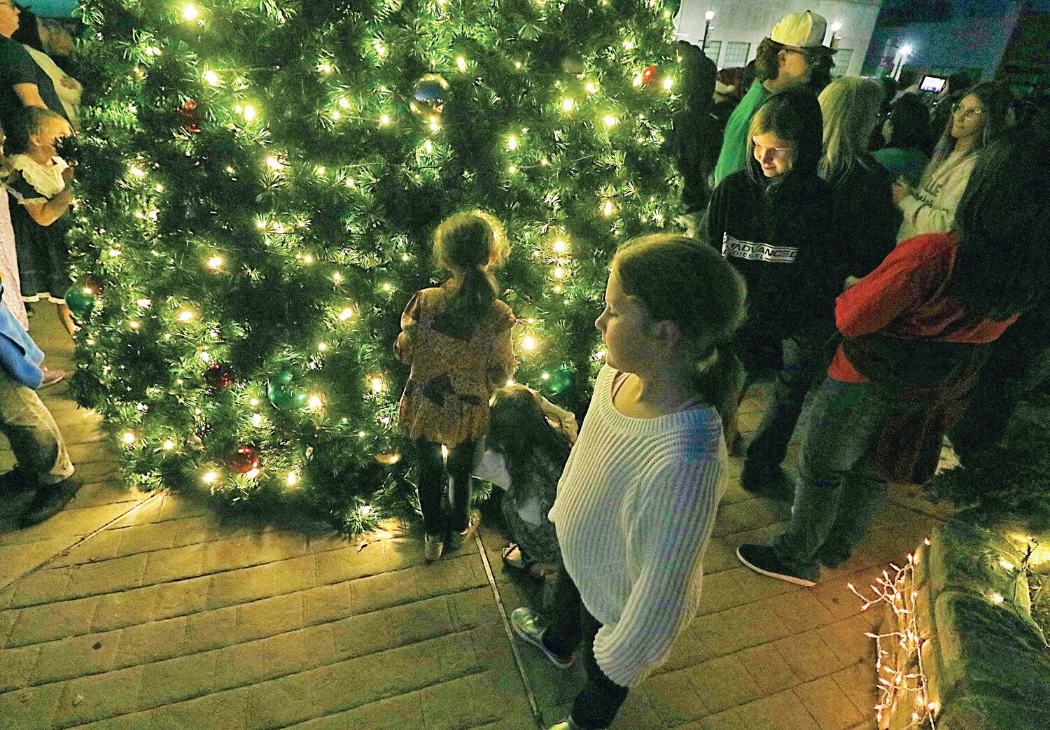 Kids take a closer look at the Christmas tree.