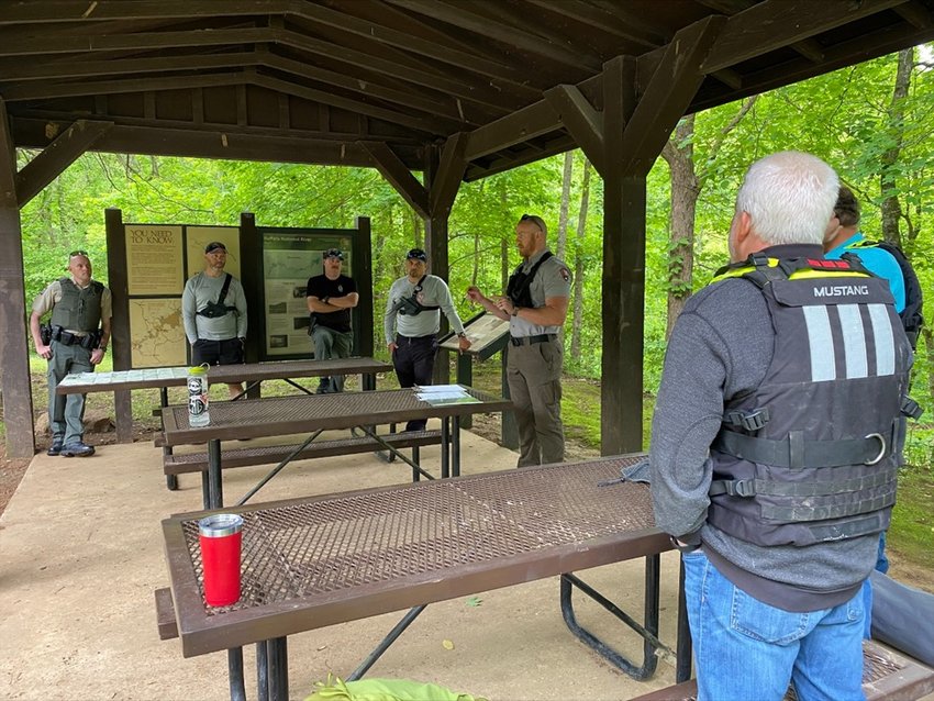 Search and rescue personnel, including Buffalo National River Rangers and Arkansas Game and Fish Wildlife Officers, discuss strategy