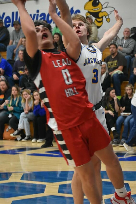 JEFF BRASEL/STAFF   Kingston's Caleb Parker (right) applies defense to Brett Arnold of Lead Hill in the 1A-1East District Tournament held in Kingston on Saturday night. The Tigers made a late fourth-quarter charge to down the Yellow Jackets. Kingston will now play in the Class 1A Region 1 Tournament on Thursday night.