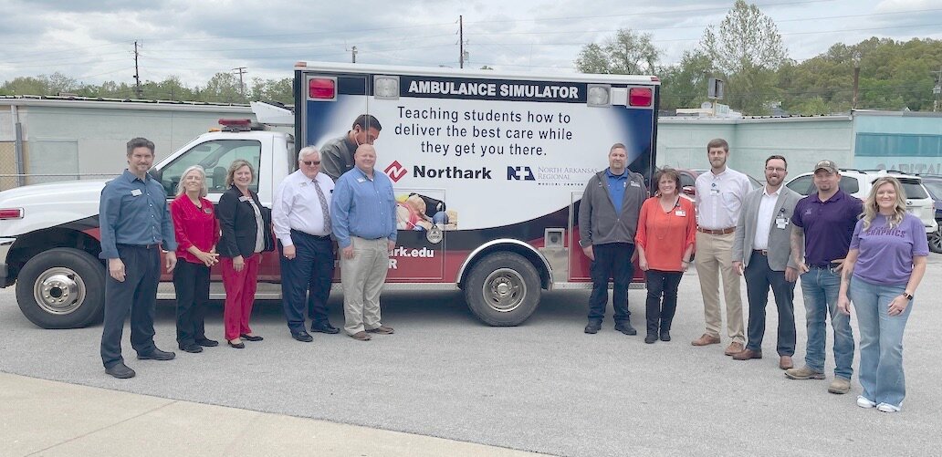 Pictured with the refurbished ambulance donated by North Arkansas Regional Medical Center to the North Arkansas College EMS/paramedic program were from left, Matt Cardin, Northark vice president of academic affairs; Laura Berry, Northark dean of health professions; Micki Somers, Northark director of public relations; Rick Massengale, Northark president; Jacob Williams, Northark director of EMS programs; Scottie Trammell, NARMC EMS director; Kim Rosson, NARMC director of marketing/community relations; Dan Dillard, NARMC donor relations and grants coordinator; Josh Bright, NARMC chief operations officer; Aubry Ralls, Kastle Graphics wrap installer and Kelly Foster, owner of Kastle Graphics of Harrison.