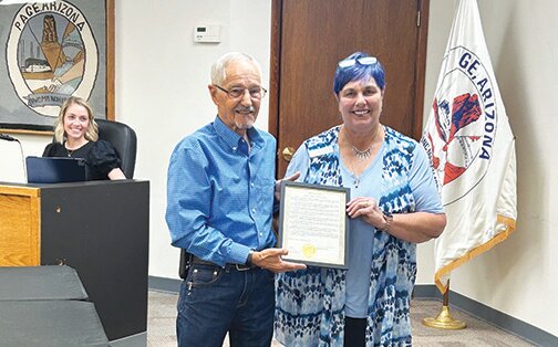 Page Mayor Bill Diak presents Dawn Pennepacker with the Domestic Violence Awareness Month Proclamation certificate.