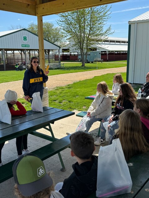 Natalie Pratt, Amboy High School junior and president of the Illinois Association FFA Section 2, displays a corn cob as she teaches a group of Amboy fifth graders during the Lee County Ag Expo on Friday, April 19 at the Lee County 4-H Center.